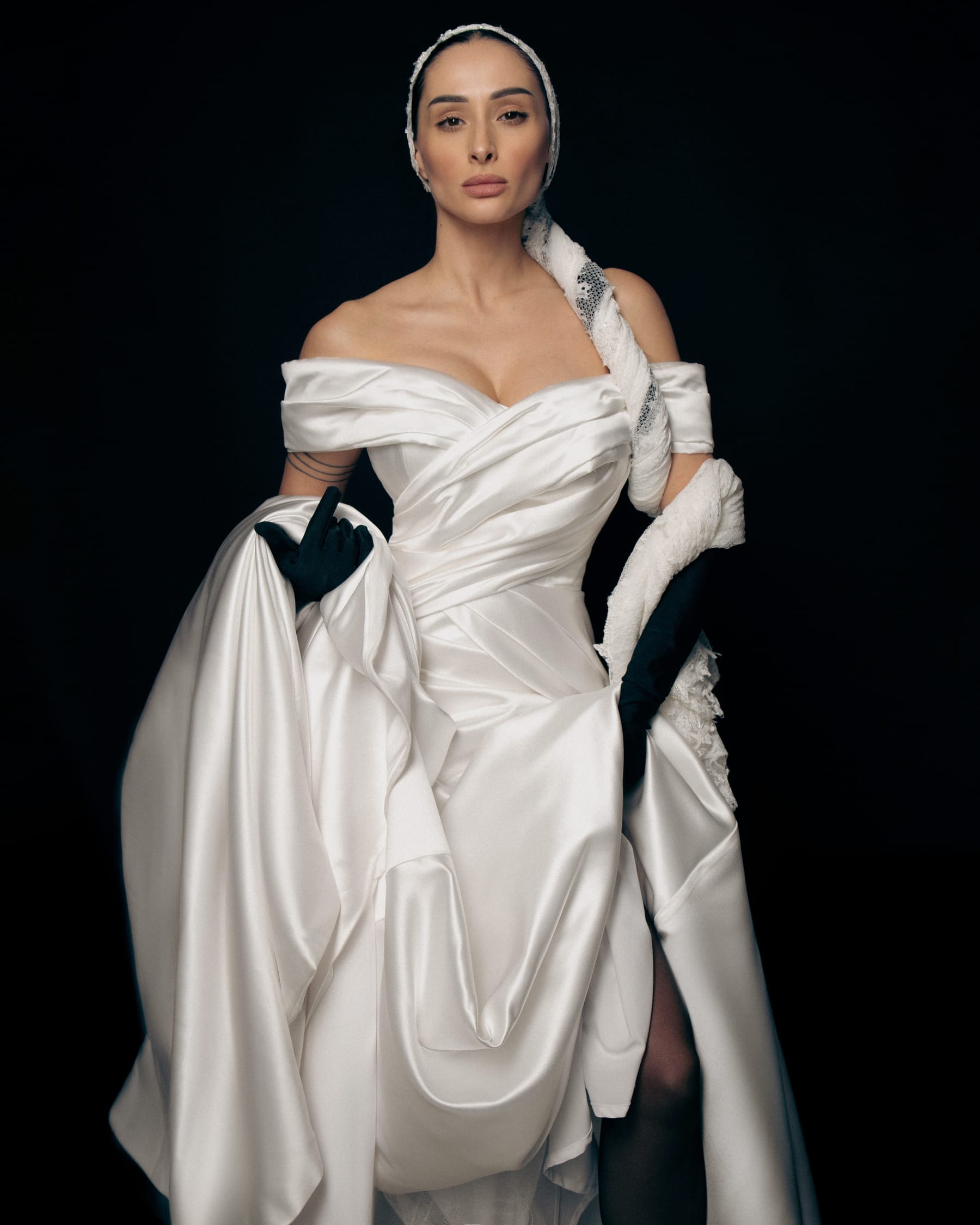 Full-length photograph from Lidiia Krejci Wedding Salon: a model in a minimalist ivory A-line gown with a high slit, in a bright studio.